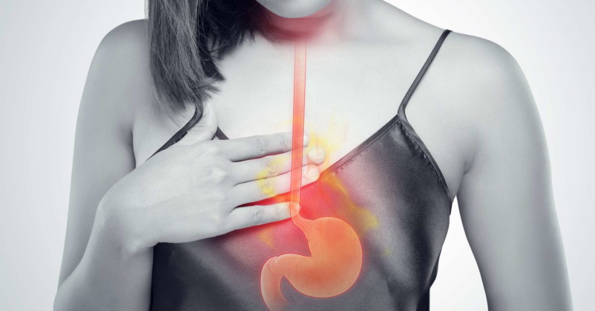 Woman feeling GERD pain with model of esophagus