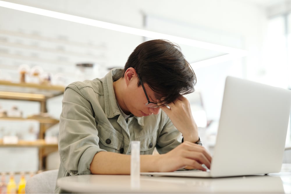 A college student looking stressed due to acid reflux.