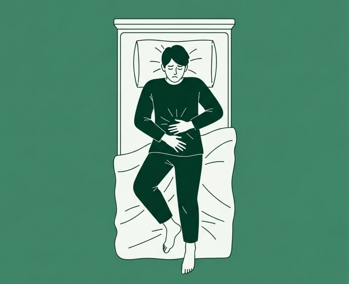 Man clenching his stomach from being bloated at night