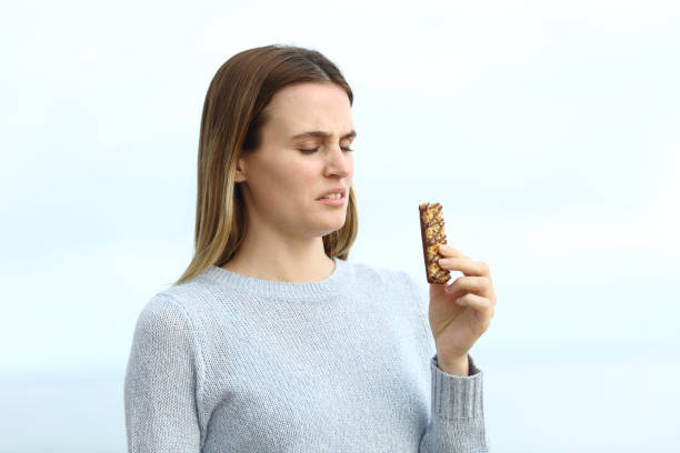 Disgusted woman looking at protein bar